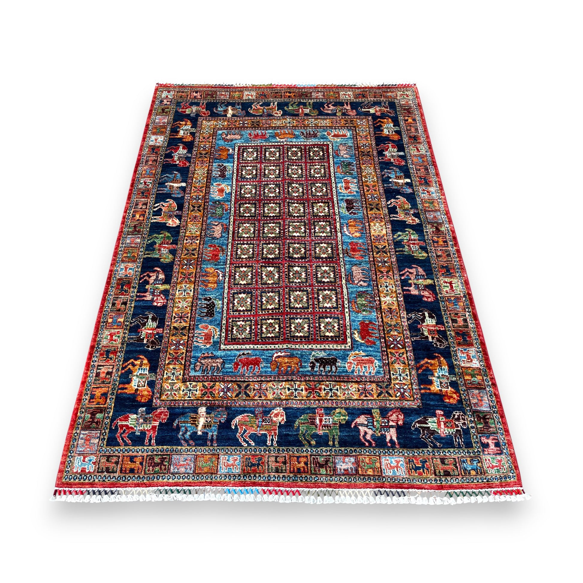 Afghan hand-knotted pictorial rug with burgundy geometric center field, navy borders featuring colorful animals including horses and riders, turquoise accents, and red outer border with white cotton fringe on white background