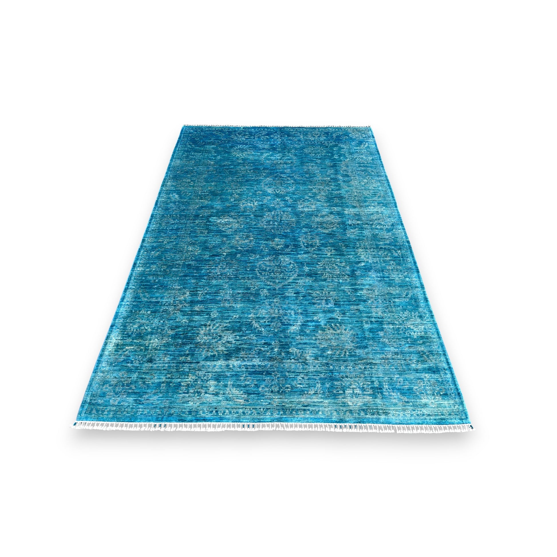 Azure blue overdyed hand-knotted wool area rug 118x80 inches with white cotton fringe, showing watercolor-like color variations and traditional craftsmanship against white background