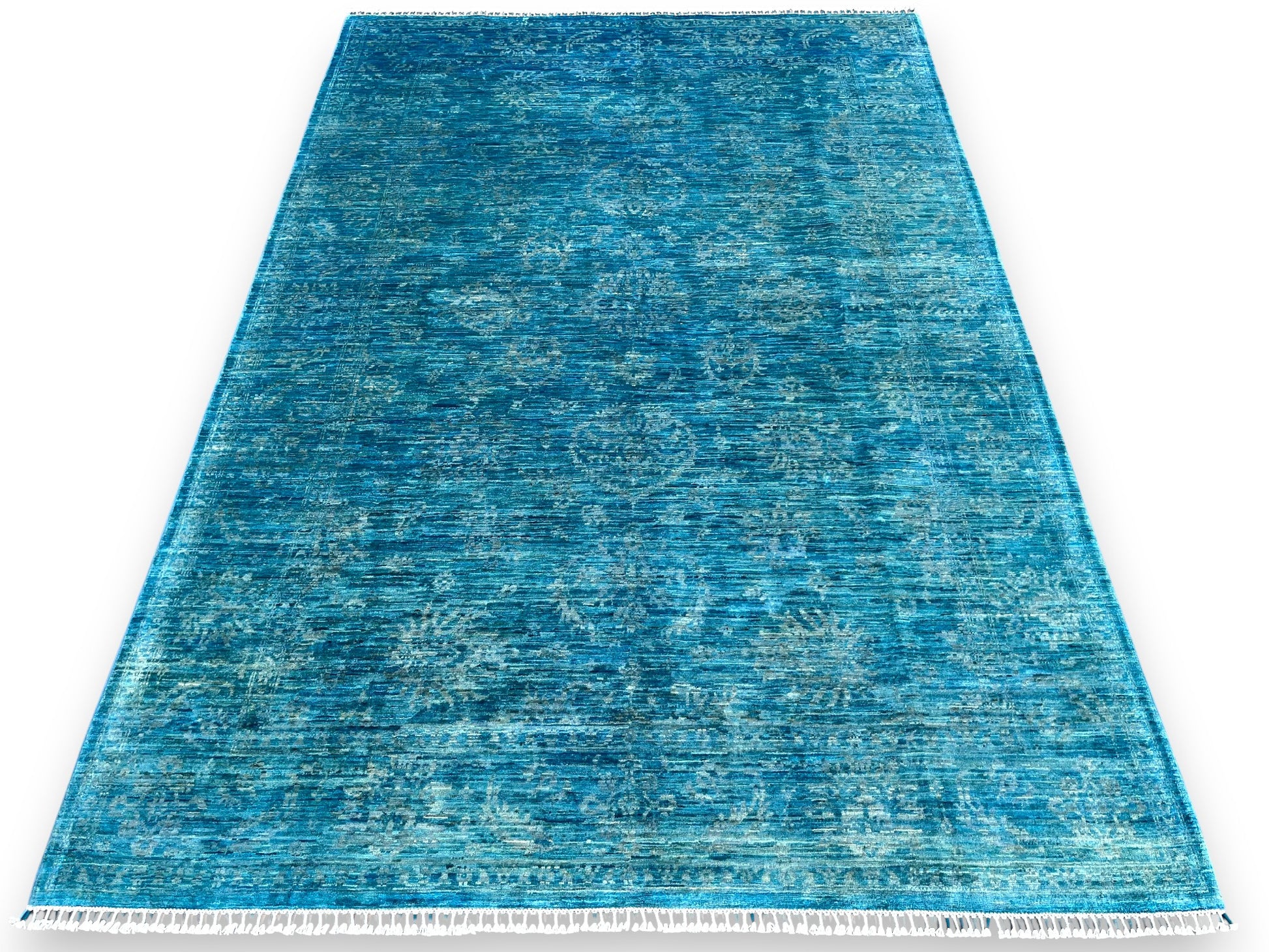 Azure blue overdyed hand-knotted wool area rug 118x80 inches with white cotton fringe, showing watercolor-like color variations and traditional craftsmanship against white background