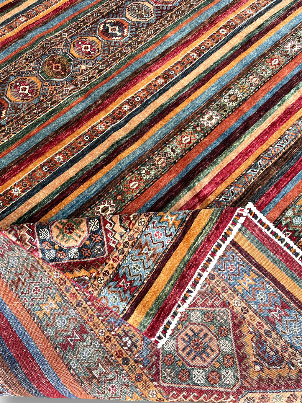 Detailed view of horizon rug fringe and color transitions between patterned and solid striped sections