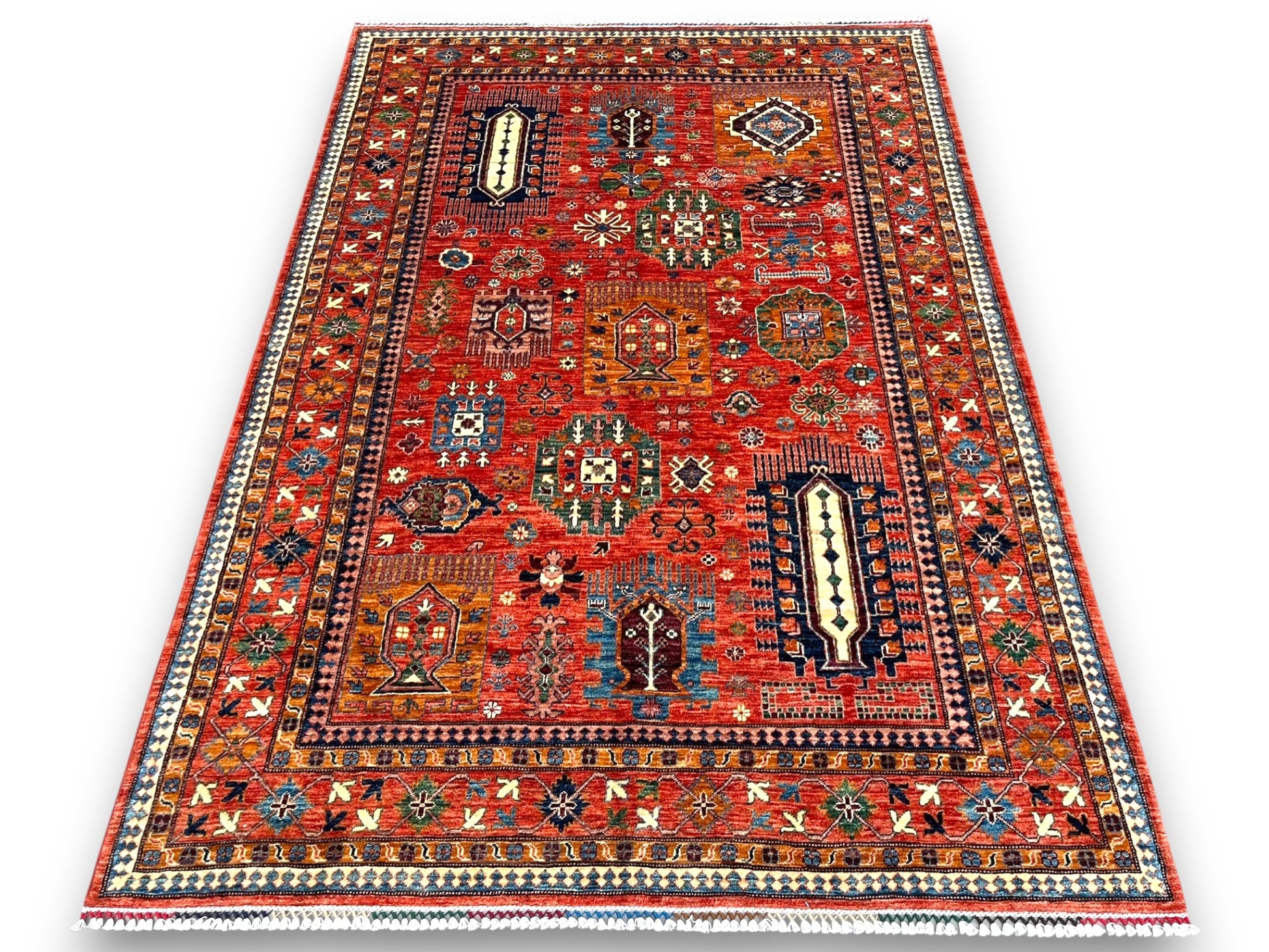 Large red Afghan cartouche rug displayed in elegant room setting showing full scale and design