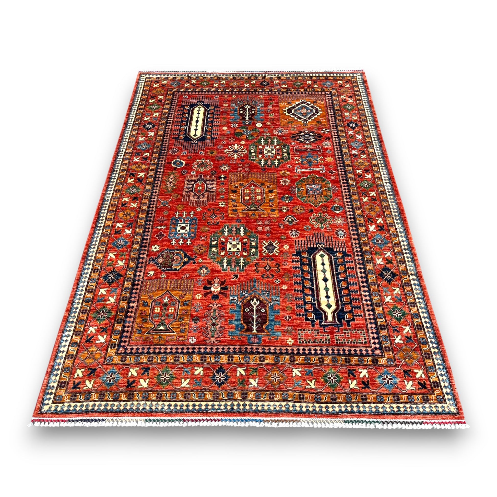 Red Afghan cartouche rug with ornate ivory medallions and geometric patterns on a white background