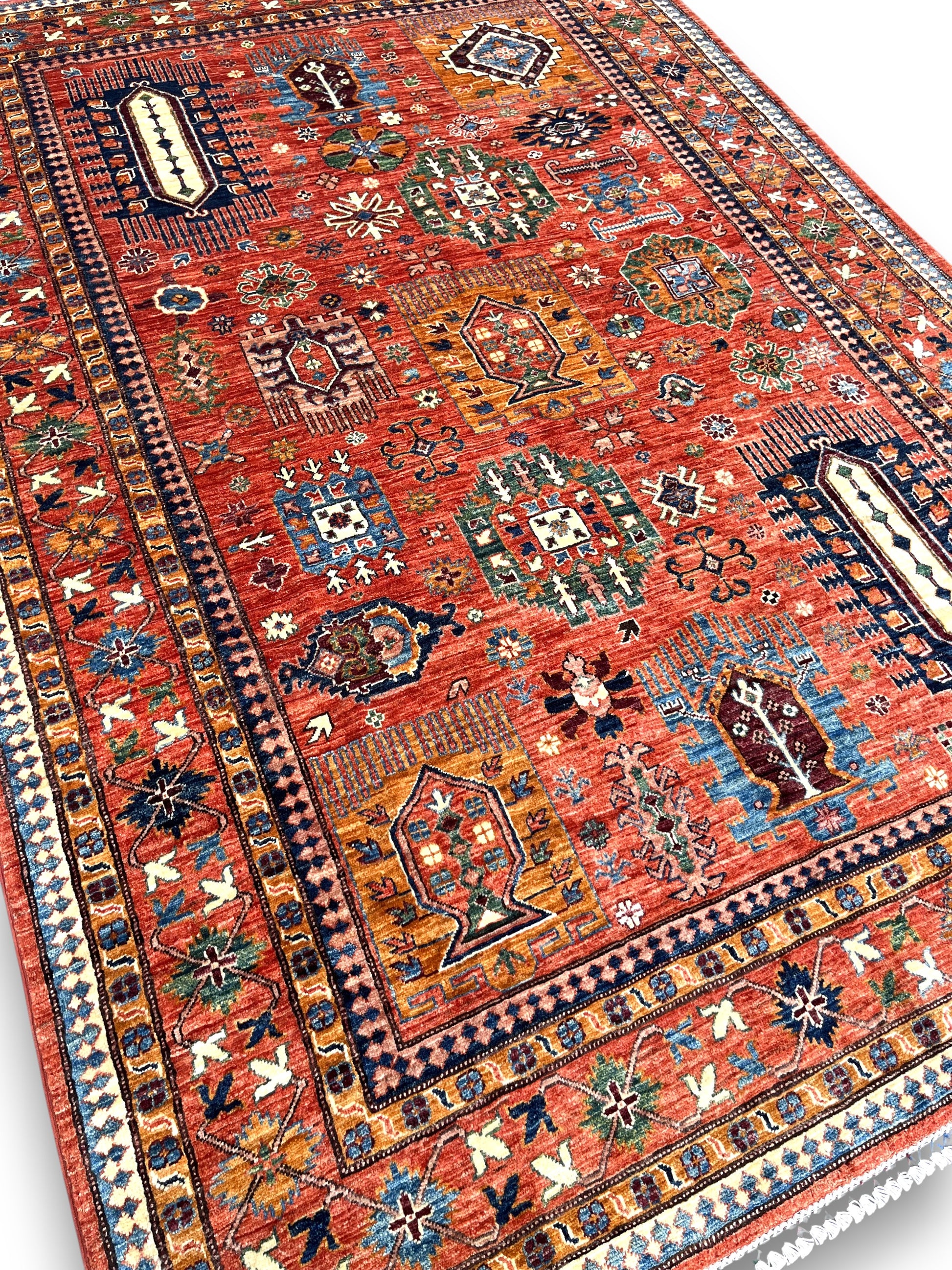 Close-up detail of Afghan cartouche rug showing intricate ivory medallions and traditional geometric motifs