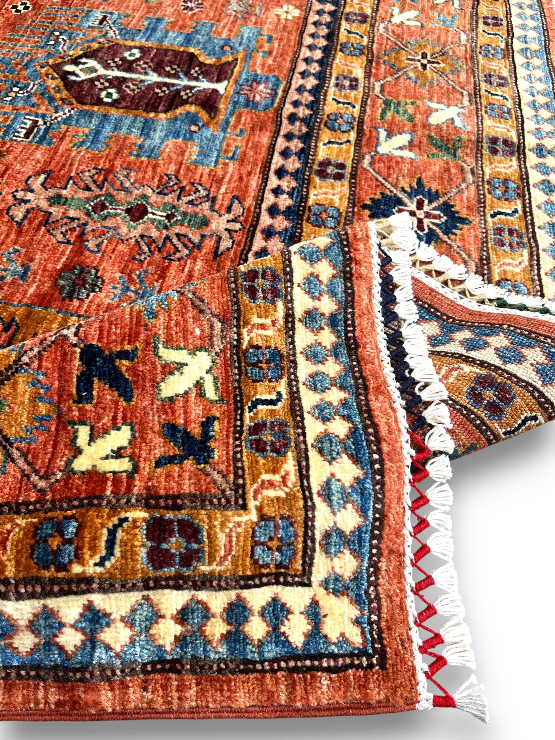 Close-up of hand-knotted wool texture and traditional fringe detail showing premium craftsmanship